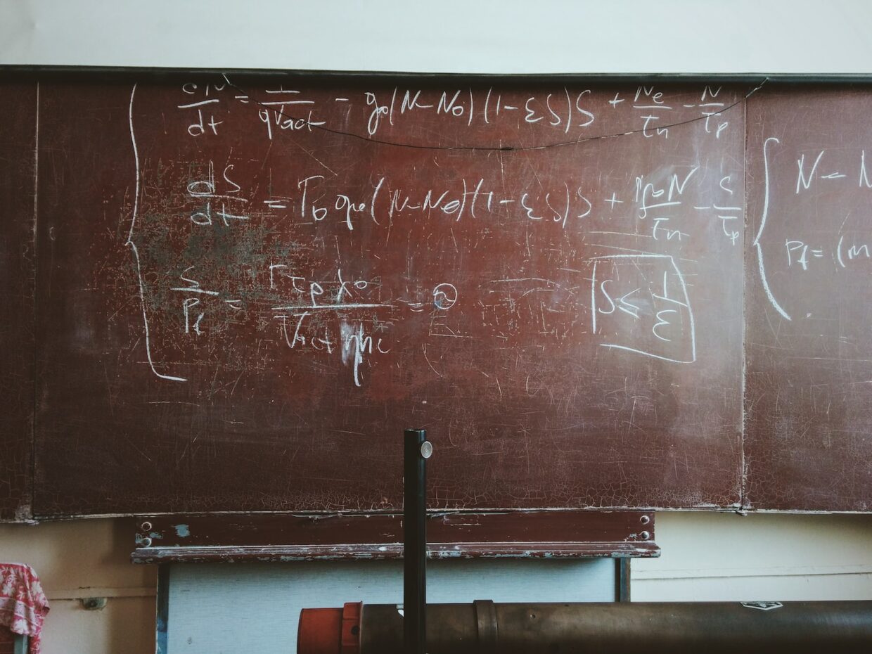 written equations on brown wooden board